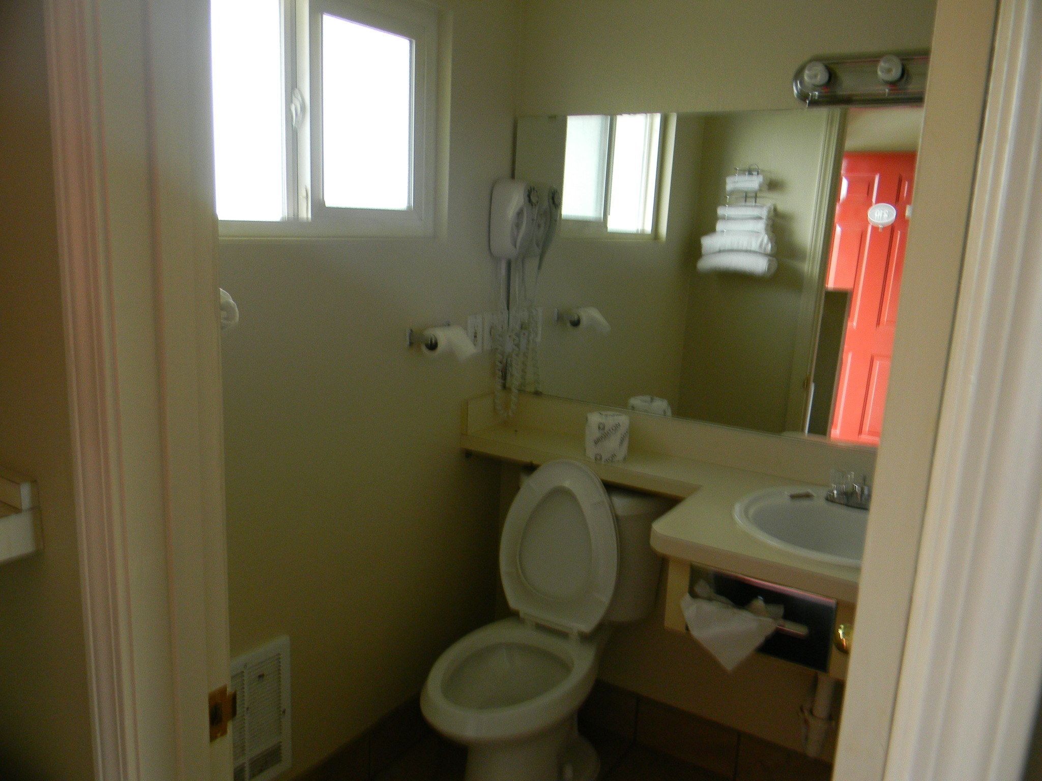 Une petite salle de bain avec des toilettes, un lavabo et un miroir.