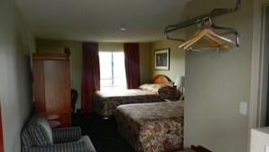 A hotel room with two beds, a chair, a desk, and a wardrobe. - Lakeview Inn Centralia (Centralia)
