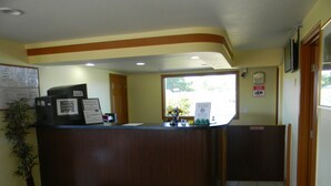 A reception desk with a computer, a bulletin board, and a plant. - Lakeview Inn Centralia (Centralia)