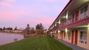 A building with a flat roof, multiple windows, and a well-maintained lawn. - Lakeview Inn Centralia (Centralia)