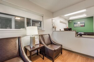 A reception area with a reception desk, two leather chairs, a lamp, and a wall-mounted sign for HomeTownne Studios.