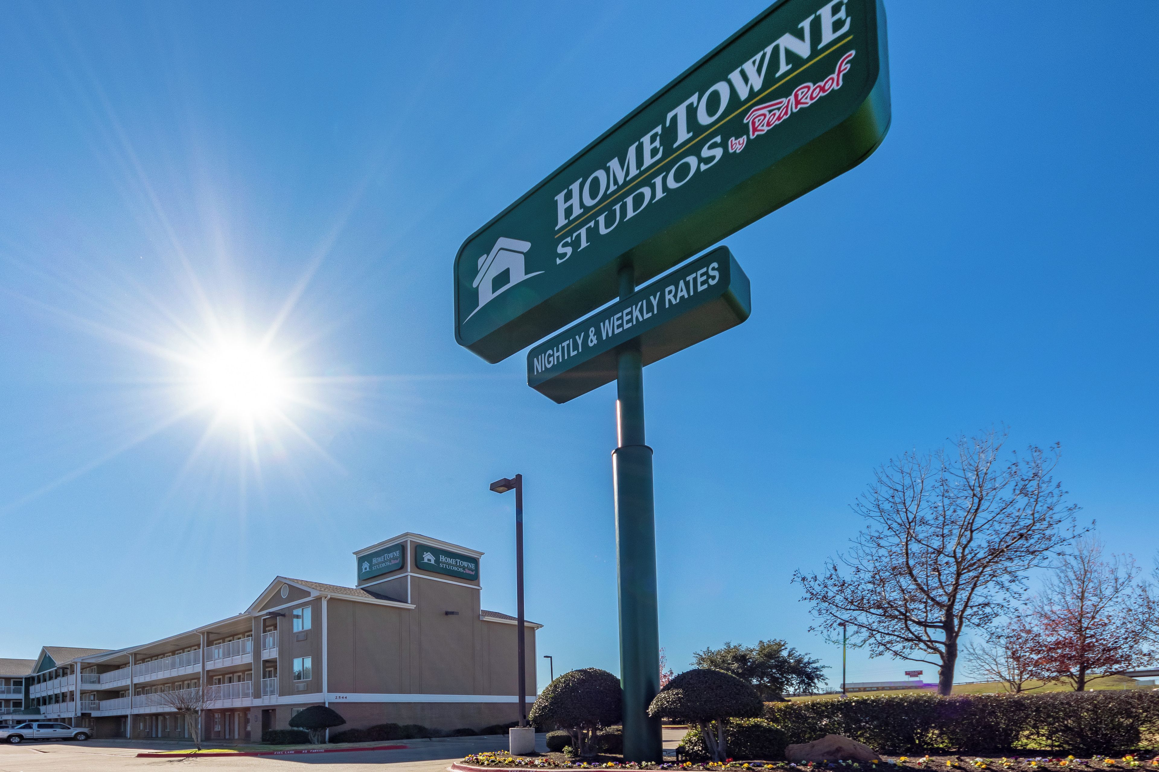 Un edificio con un letrero que indica 'Home Towne Studios' y 'Tarifas por noche y semanal'.