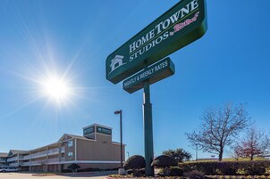 Un edificio con un letrero que indica 'Home Towne Studios' y 'Tarifas por noche y semanal'.