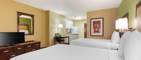 A hotel room with two beds, a desk, a chair, a television, and a mirror.