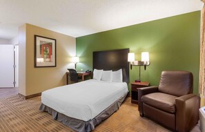 A hotel room with a bed, a desk, a chair, and a nightstand. - Extended Stay America Suites Washington DC Gaithersburg N (Gaithersburg)