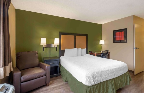 A hotel room with a bed, a chair, a desk, and a nightstand. - Extended Stay America Suites Chicago Woodfield Mall (Schaumburg)