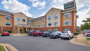 Un hotel con un cartel que dice "Extended Stay America" y un estacionamiento con varios autos.