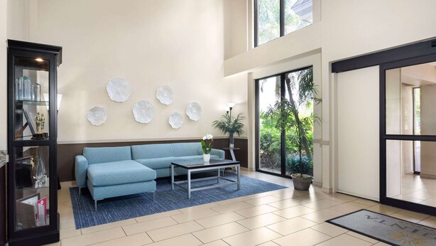 Un hall d’entrée moderne avec un canapé bleu, une table basse et des assiettes décoratives accrochées au mur.