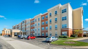 A multi-story hotel with a parking lot in front.