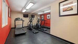 A fitness room with treadmills, stationary bikes, and a mirrored wall.