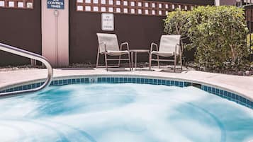 Un jacuzzi con dos sillas y un cartel con el temporizador de control.