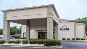 A Days Inn with a covered entrance, a parking lot, and a landscaped area with bushes. - Days Inn by Wyndham Lugoff (Lugoff)