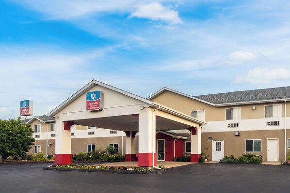 A hotel with a covered entrance, multiple rooms, and a parking lot. - SureStay Plus Hotel by Best Western Bettendorf (Bettendorf)
