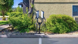 Zwei Ladestationen für Elektrofahrzeuge an einem Metallständer, im Hintergrund eine Betonmauer.