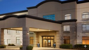 A modern hotel entrance with a covered entrance, large windows, and a well-lit facade. - Townhome Inn And Suites (Cordova)