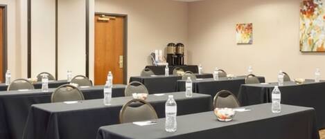 A conference room with tables set up for meetings, equipped with water bottles and nameplates.