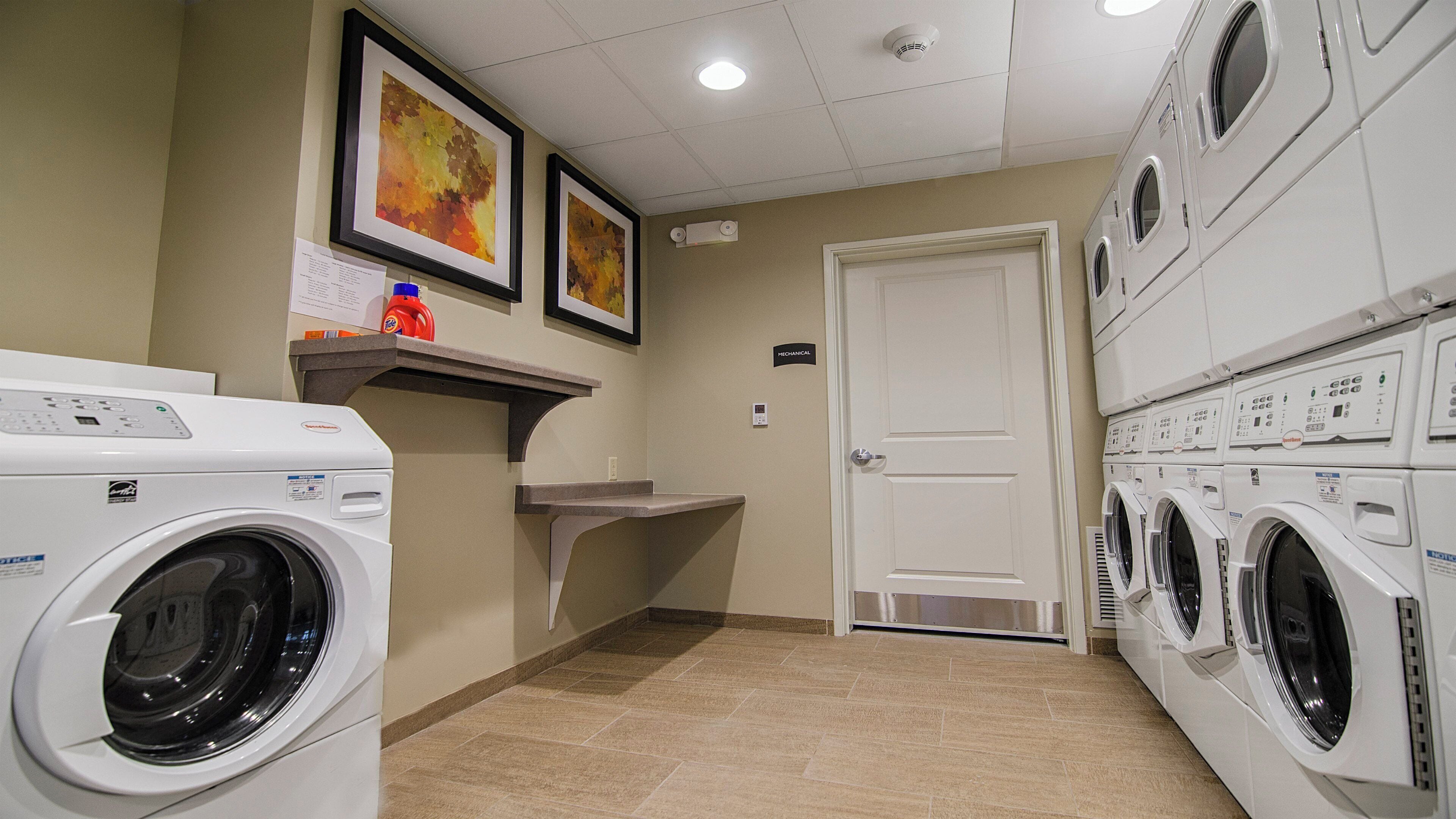 Un lavadero con varias lavadoras, un lavabo y una puerta con la leyenda 'Mecánica'.