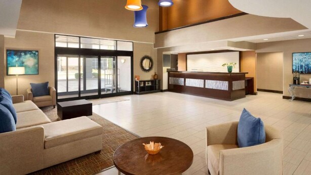 A spacious lobby with a reception desk, seating area, and large windows. - Townhome Inn And Suites (Cordova)