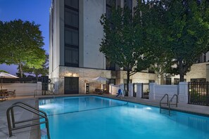 A swimming pool with a stone facade building in the background. - Hyatt Place Austin The Domain Area (Austin)