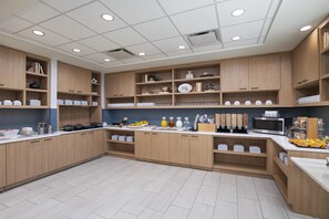 A modern kitchen with wooden cabinets, white countertops, and various kitchen appliances. - Hyatt Place Austin The Domain Area (Austin)