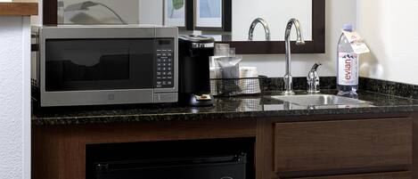 Cocina compacta con microondas, cafetera, pileta y lavavajillas.