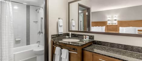 Un baño de hotel con bañera, inodoro y ducha.