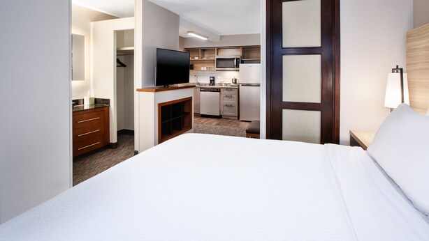 Une chambre d’hôtel équipée d’un lit, d’une télévision, d’une kitchenette et d’une salle de bain.