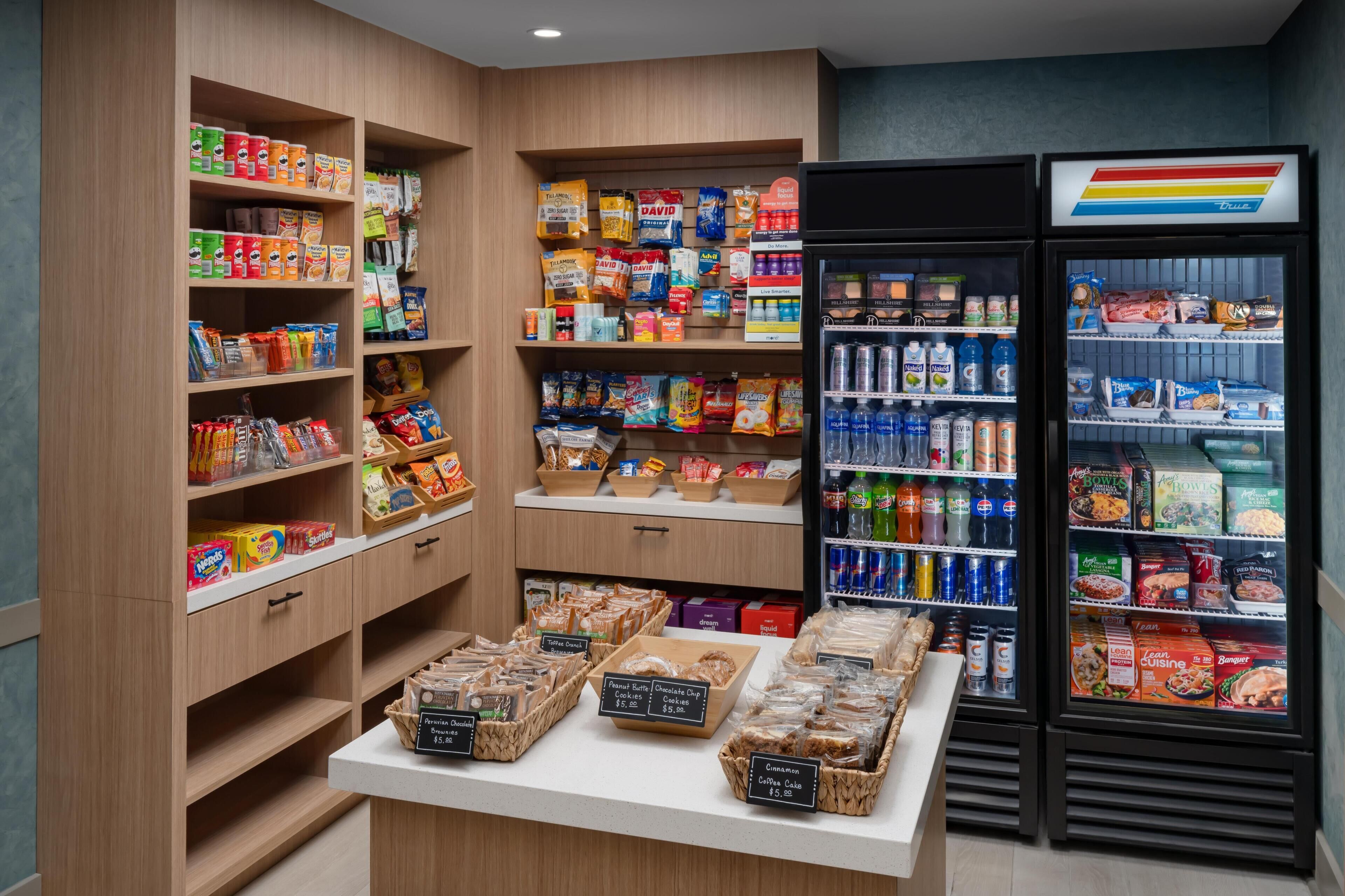 A grocery store with shelves stocked with snacks, beverages, and boxed goods.