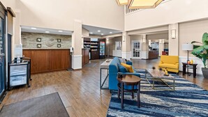 A spacious lobby with a reception desk, seating area, and a staircase. - Comfort Suites Daphne - Mobile East Bay (Daphne)