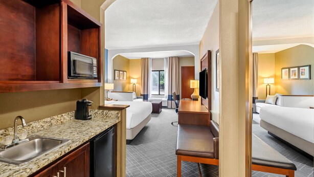 A hotel room with a kitchenette, a bed, a desk, and a bathroom. - Comfort Suites Daphne - Mobile East Bay (Daphne)
