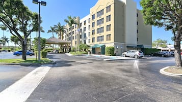 Un hotel de varios pisos con estacionamiento y una galería techada.