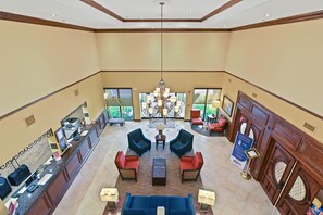 A lobby with a reception desk, seating area, and a chandelier.