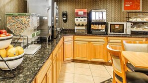 A breakfast bar with a bowl of fruit, a coffee machine, a microwave, and a toaster. - Comfort Inn Owatonna near Medical Center (Owatonna)