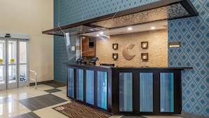 A reception desk with a modern design, a check-in counter, and a digital display.