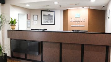 Een receptiebalie met een bordje waarop 'Quality Inn by Choice Hotels' staat.