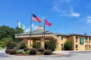 A hotel with a covered entrance, American and state flags, and a Quality Inn sign.