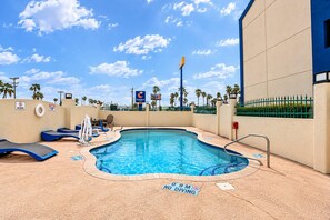 A swimming pool with lounge chairs and a no diving sign.
