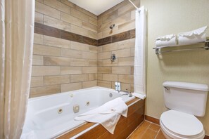 A bathroom with a bathtub, toilet, and towel rack.
