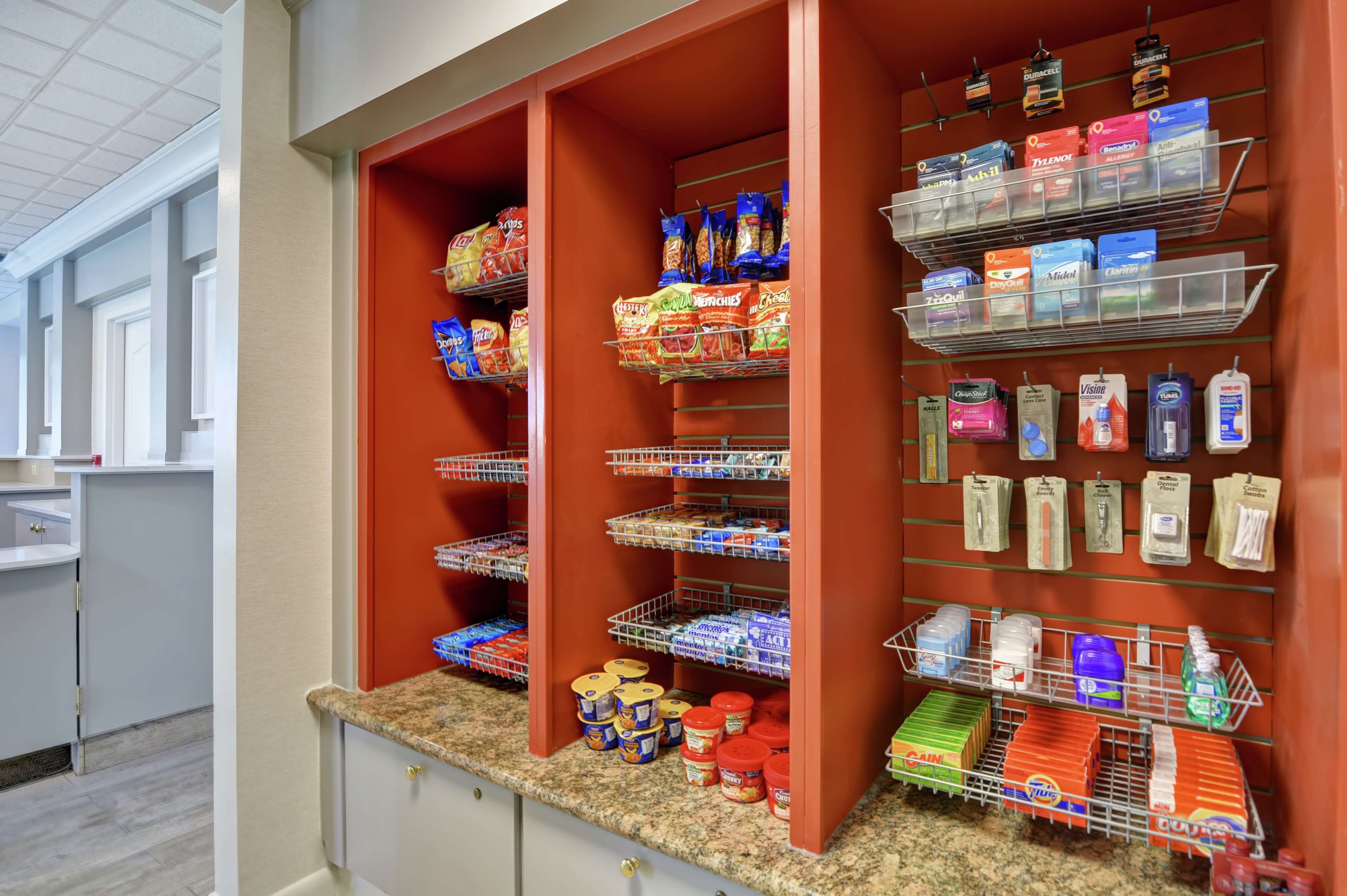 A well-organized pantry with shelves stocked with snacks, beverages, and household items.