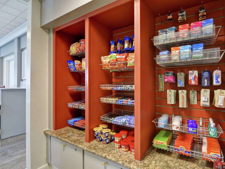 A well-organized pantry with shelves stocked with snacks, beverages, and household items.