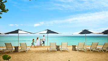 On the beach, white sand, beach cabanas, beach towels
