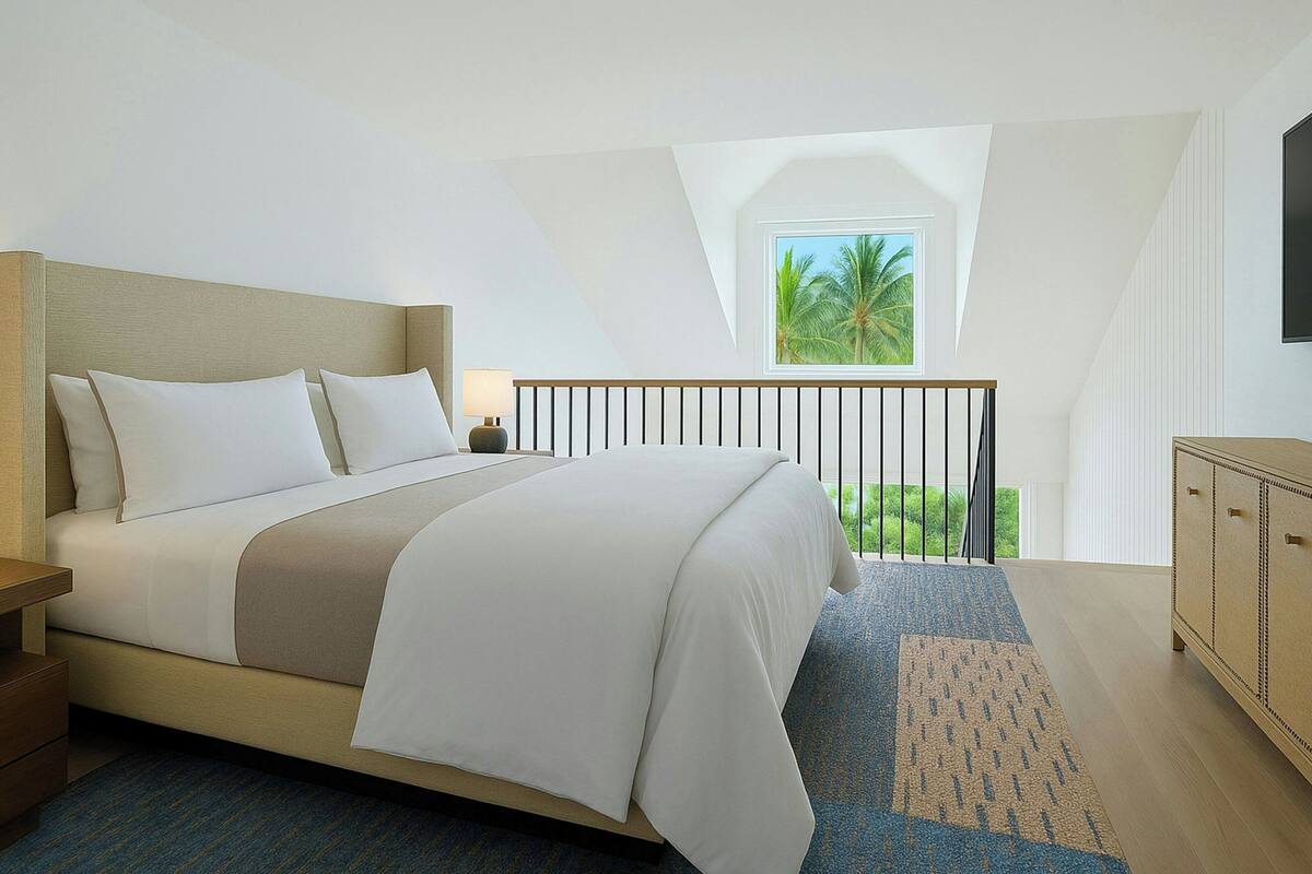 A bedroom with a bed, a nightstand, a dresser, a window with a view of palm trees, and a balcony railing.