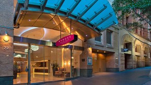 The exterior of Rydges Darling Square Hotel with a glass entrance, a reception area visible inside, and a modern architectural design. - Rydges Darling Square Apartment Hotel (Sydney)