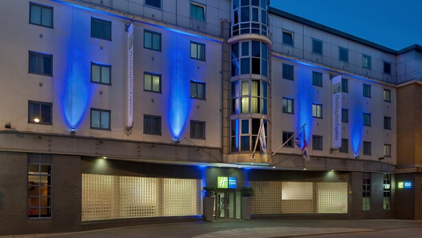 A modern hotel with a curved corner, multiple windows, and a prominent entrance with a sign. - Holiday Inn Express London City by IHG (London)