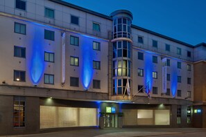 A modern hotel with a curved corner, multiple windows, and a prominent entrance with a sign. - Holiday Inn Express London City by IHG (London)