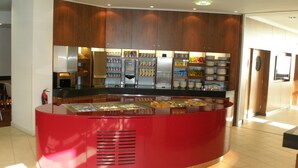 A modern kitchen with wooden cabinets, a red countertop, and a coffee machine. - Holiday Inn Express London City by IHG (London)