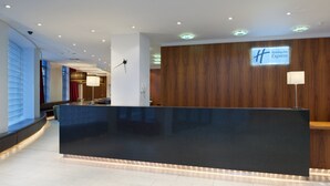 A modern reception desk with a Holiday Inn Express sign, a wooden wall, and a well-lit interior. - Holiday Inn Express London City by IHG (London)