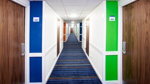 A hotel corridor with doors numbered 424 and 425, featuring a blue carpet and wooden doors. - Holiday Inn Express London City by IHG (London)