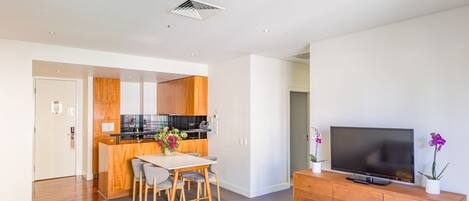 A modern apartment with a kitchen, dining area, and living room.