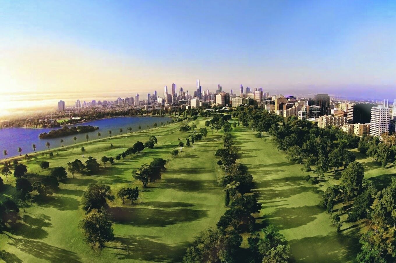 A cityscape with a large park and a body of water.